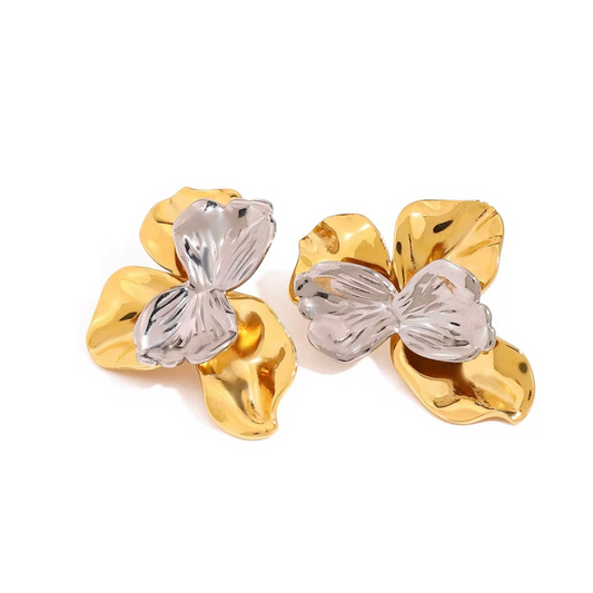 Pair of gold and silver flower-shaped earrings on a white background