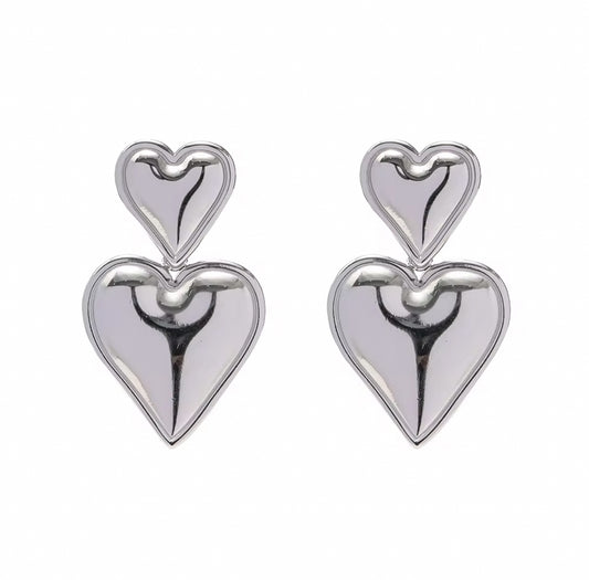 Pair of silver heart-shaped earrings on a white background