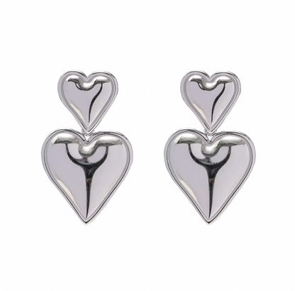 Pair of silver heart-shaped earrings on a white background