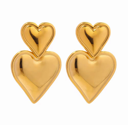 Pair of gold heart-shaped earrings on a white background