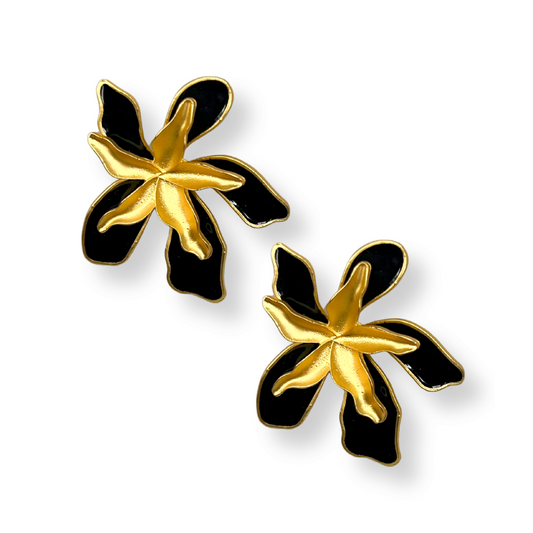 Pair of gold and black flower-shaped earrings on a white background
